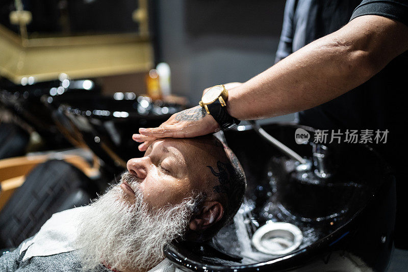 一个成熟的男人在理发店洗头