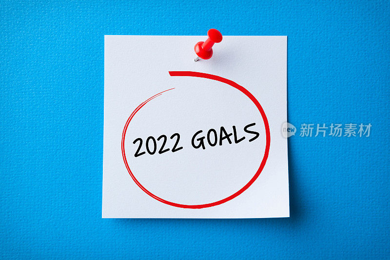 白色便利贴与新年2022年目标和红色图钉在蓝色背景