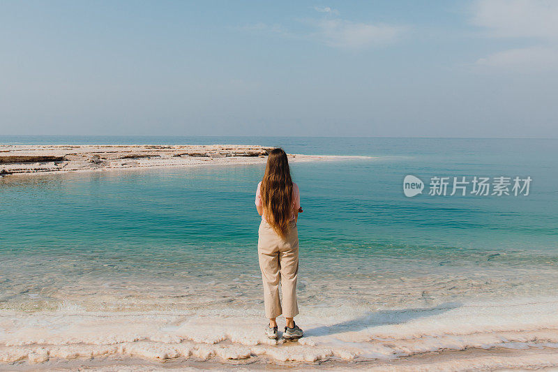 女性旅行者探索约旦死海的蓝绿色海水