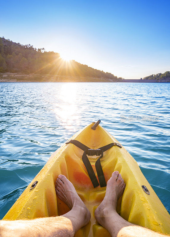 日落时分，男子在加泰罗尼亚埃布罗河的湖中划皮艇