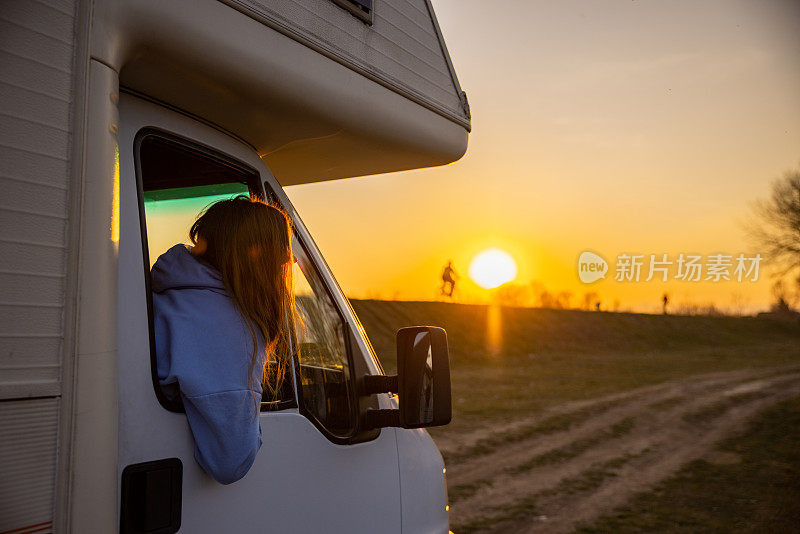 宁静的女人享受日落期间露营骑