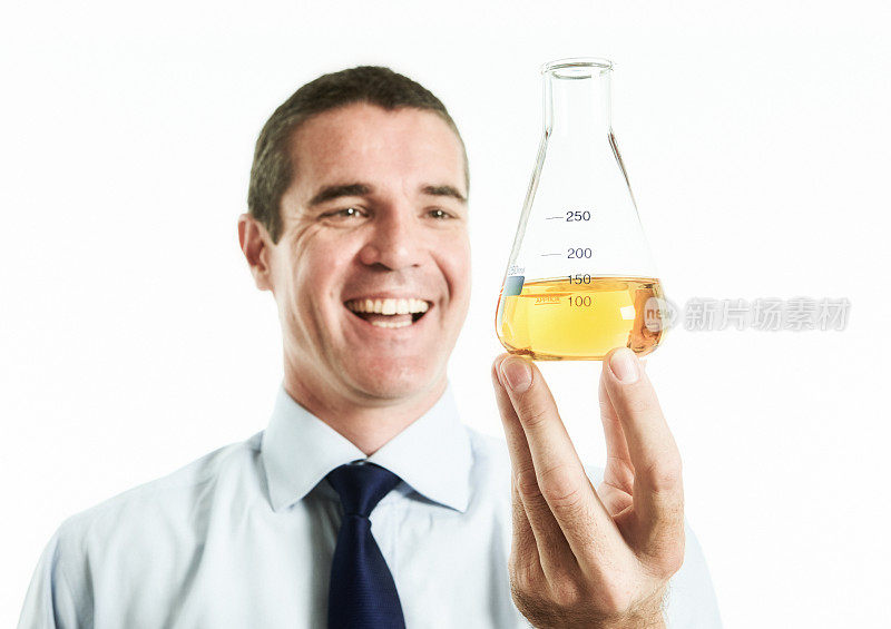 当医生或科学家检查一个装满黄色液体的实验室烧瓶时，他笑得很开心