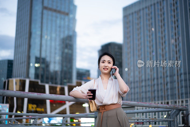 亚洲商业女性站在城市街头，写字楼背景，成功、自信的女性理念