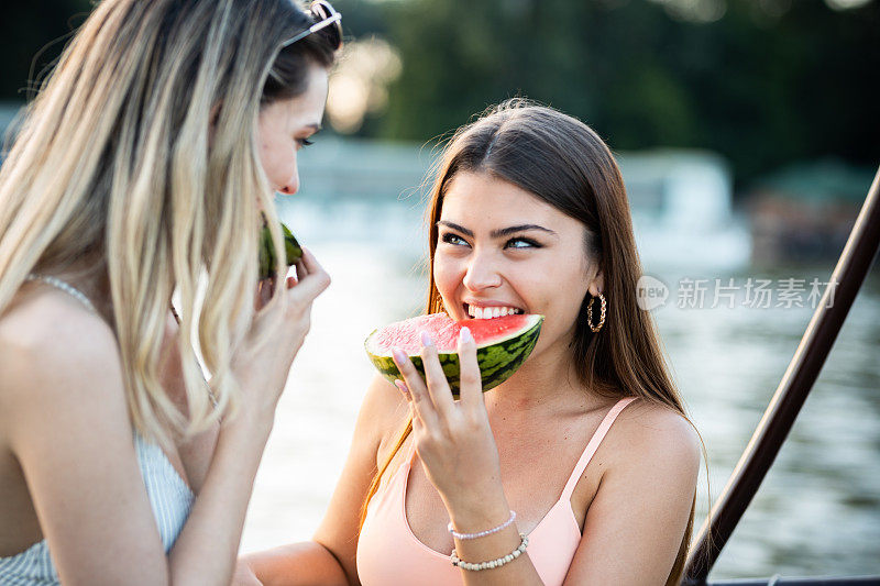 姑娘们在河船上吃西瓜