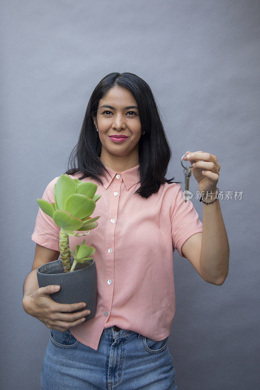 女人拿着植物和钥匙