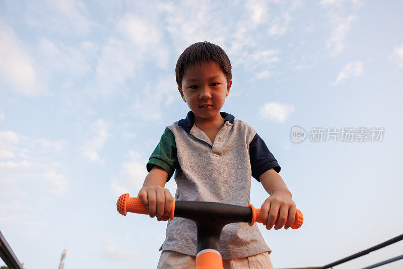 这个小男孩正在学骑自行车