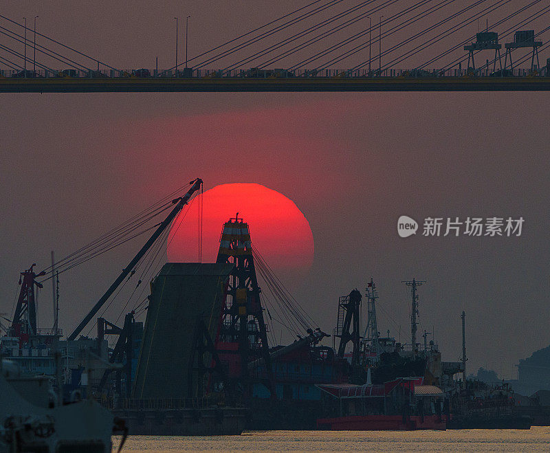 日落时的太阳正好落在浮吊上和汀九桥下