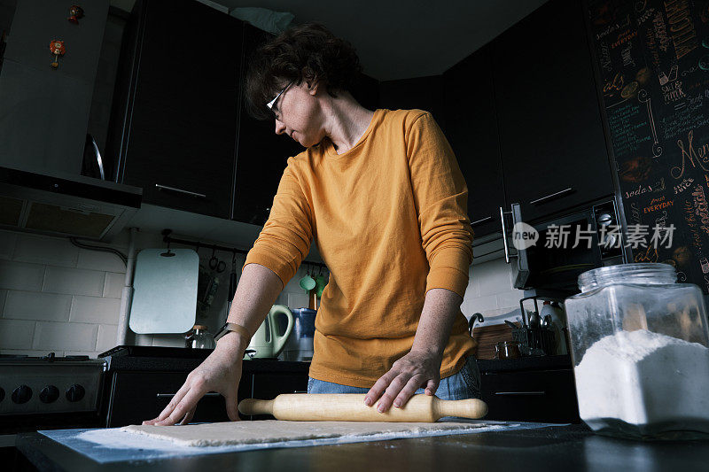 一位女士正在准备自制的苹果蜜饯甜卷