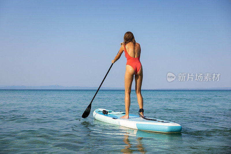 不认识的女人用站立式桨板探索大海