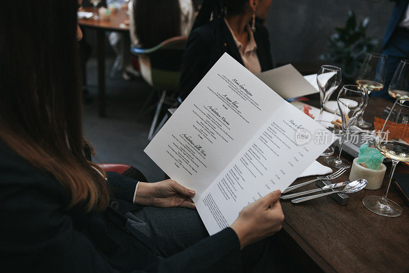 一名女子在餐厅阅读菜单