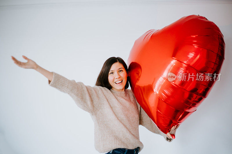 美丽的年轻女子与心形气球