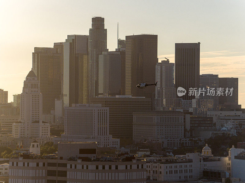 洛杉矶警察局的直升机飞过洛杉矶，市中心的摩天大楼为背景