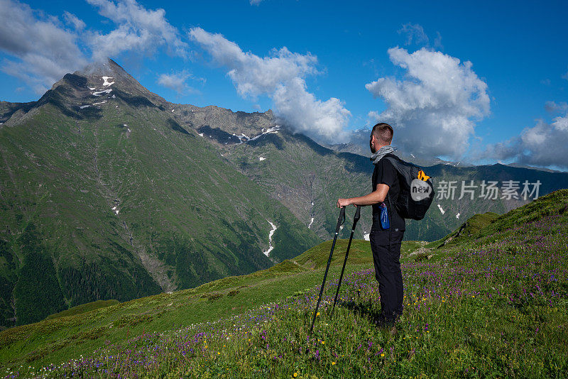 在山上散步。徒步旅行者欣赏山顶景色。