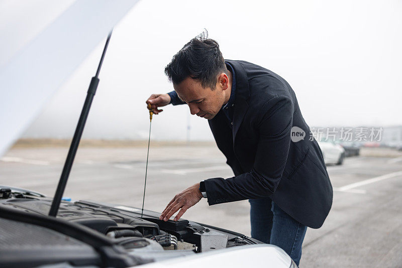 一名男子正在检查汽车发动机油