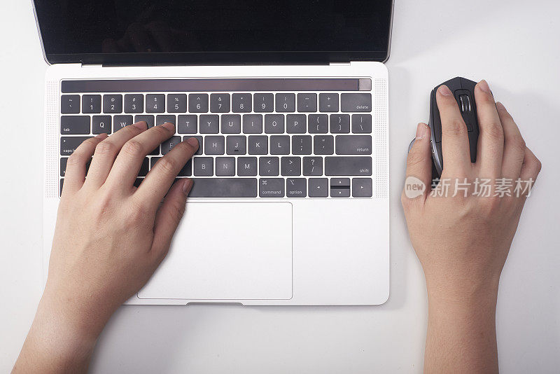 一位商务人士正在使用笔记本电脑和鼠标