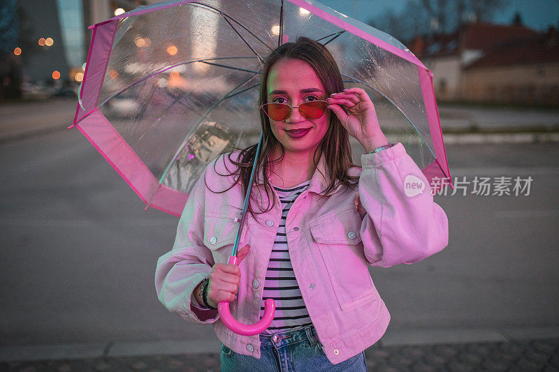 一个戴着墨镜的美女在雨夜撑着伞散步的画像