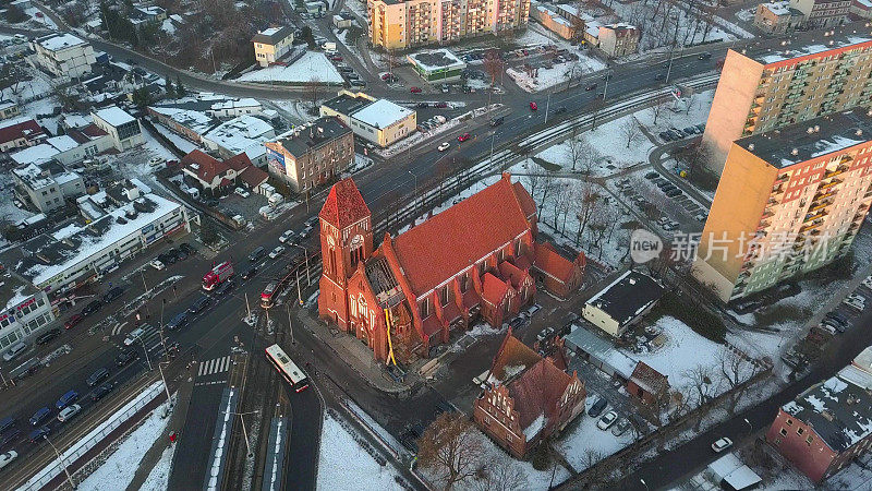 冬季被公寓楼包围的哥特式砖砌教堂航拍图