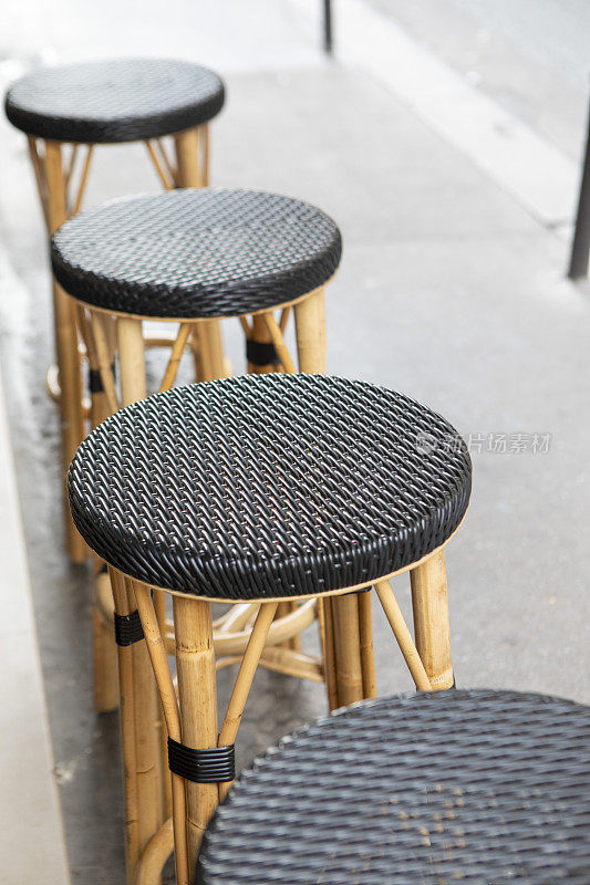 酒吧的凳子在人行道上排成一排