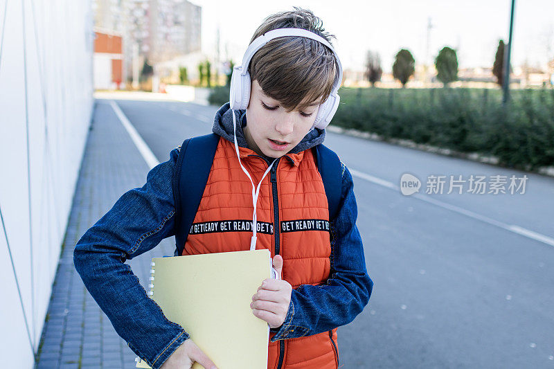 一个戴耳机的男生放学后要回家。