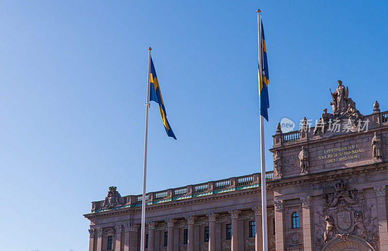 挂着瑞典国旗的瑞典议会大厦。蓝色的天空。老城区的历史建筑。斯德哥尔摩,瑞典