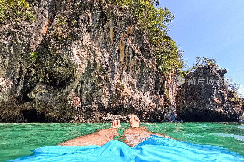 年轻男子的脚，因为他漂浮在安达曼海在泰国的老挝提拉岛