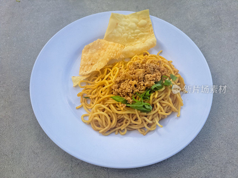 美味的炸面条，饺子，切碎的香葱和鸡肉屑。炸面配饺子，葱花和洒在上面的鸡肉。食品菜单。