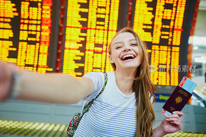 女孩在机场，用护照和登机牌自拍