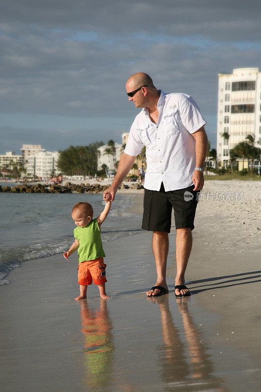 爸爸和儿子在海滩上散步