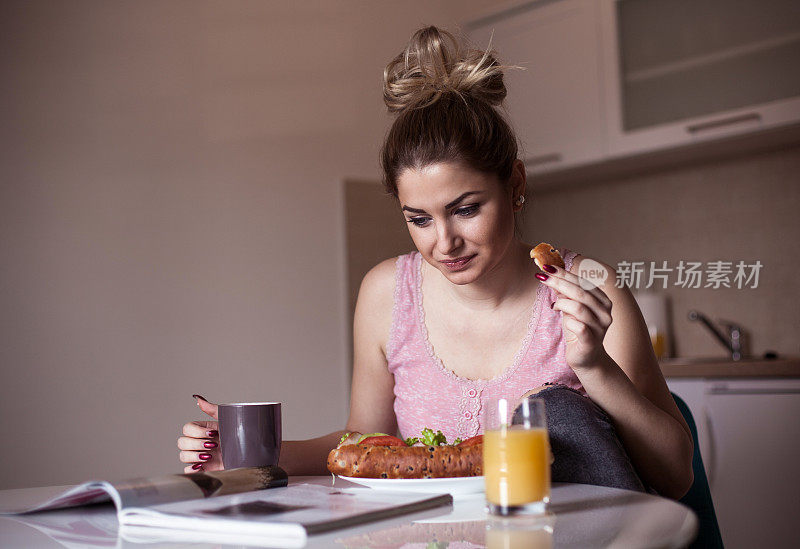 在餐桌上看报纸的女人