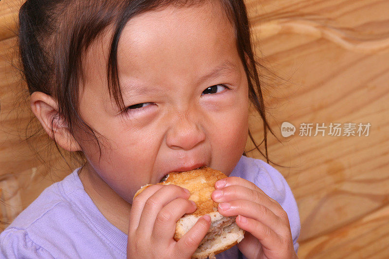 小女孩正在大嚼汉堡