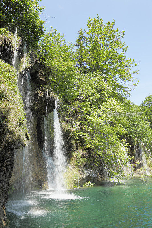 垂直的瀑布和水流进入绿色的池塘克罗地亚Plitvice