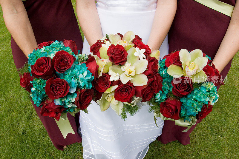 新娘和伴娘抱着令人瞠目结舌的彩色花束玫瑰婚礼
