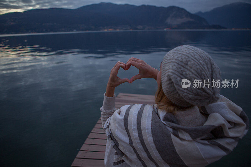 年轻女子在湖边码头休息，热爱大自然