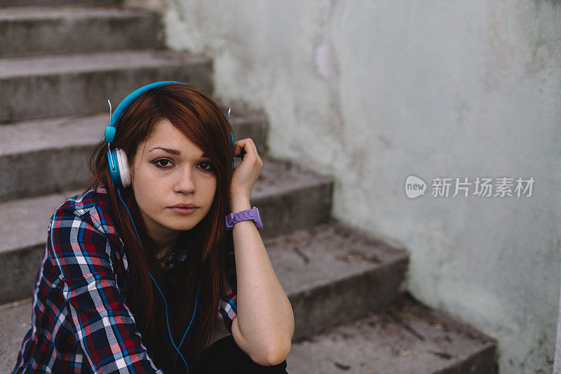 抑郁的少女戴着耳机
