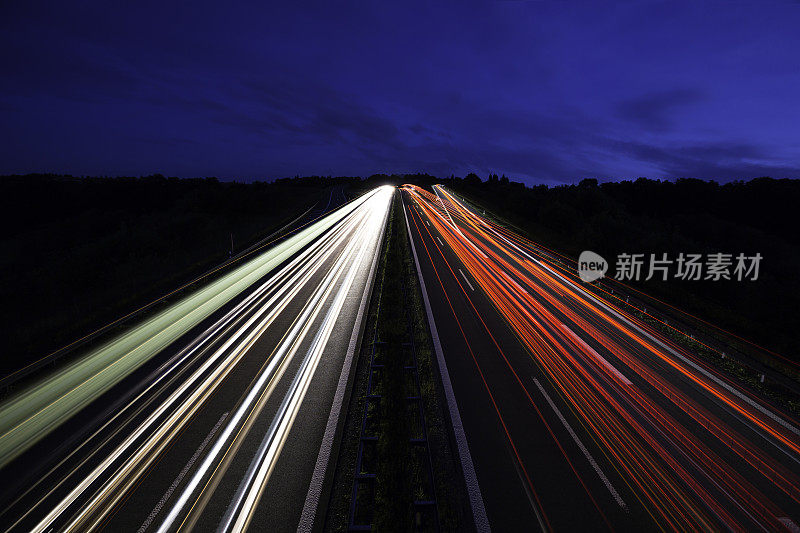 公路上的夜晚:夜幕降临后，公路上出现了灯光