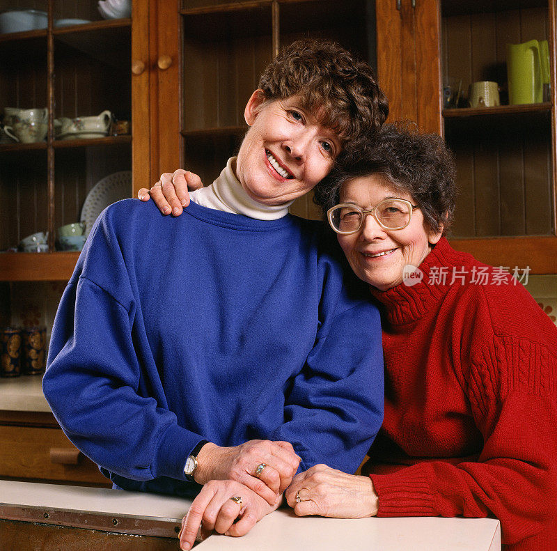一位老妇人和她的女儿在厨房里微笑。