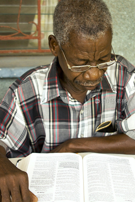 年长非洲人在读他的圣经。