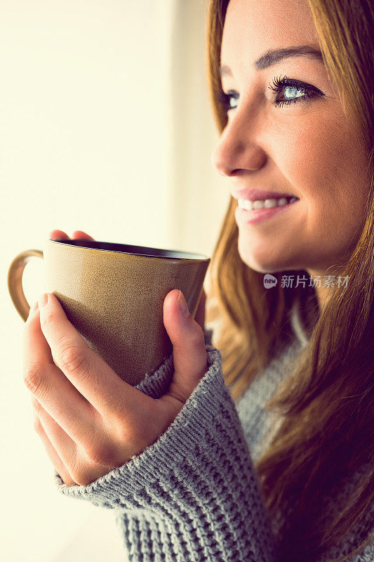 可爱的女人拿着一个杯子