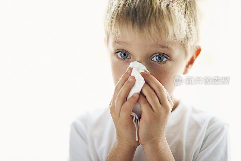 小男孩用感冒清洗他的流鼻涕。
