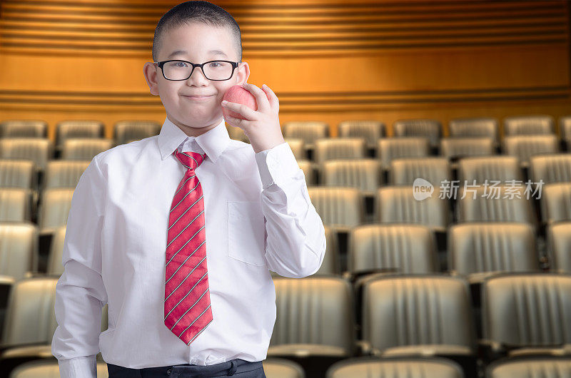 快乐微笑的小商务男孩在会议厅的背景