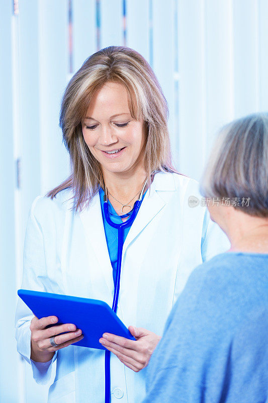 医生医师与资深女性病人阅读平板电脑信息