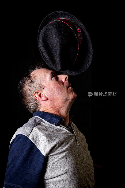 一个成熟的男人把毡帽顶在鼻子上