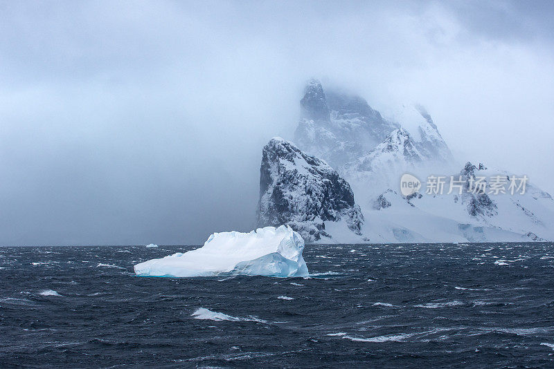 冰山漂浮在南极洲，后面是山脉