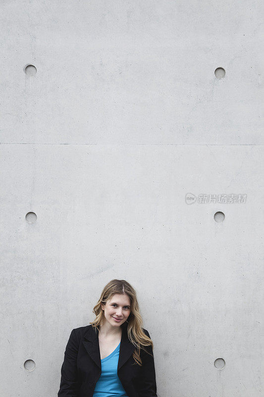 德国，柏林，一个微笑着靠墙站着的女人，肖像