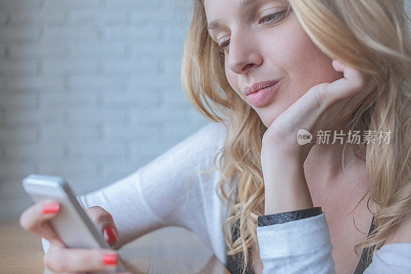 沉思的年轻女子，在智能手机上输入短信