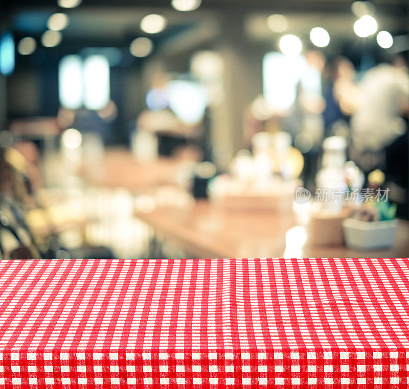 空桌子与红色格子桌布模糊的咖啡馆与散景背景，食物和产品展示蒙太奇