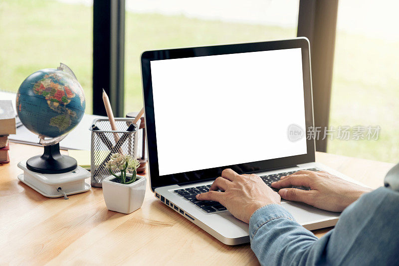近距离观察年轻的商业女性坐在办公桌前，在办公室的笔记本电脑上工作，敲击键盘，努力工作确保成功