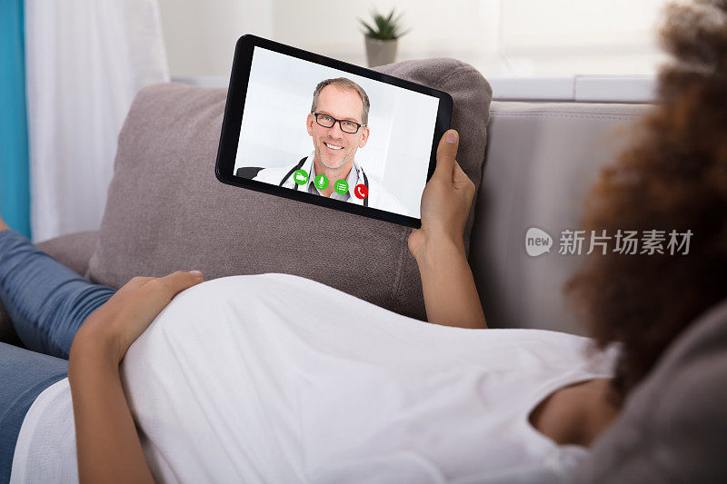 孕妇通过平板电脑与医生进行视频会议
