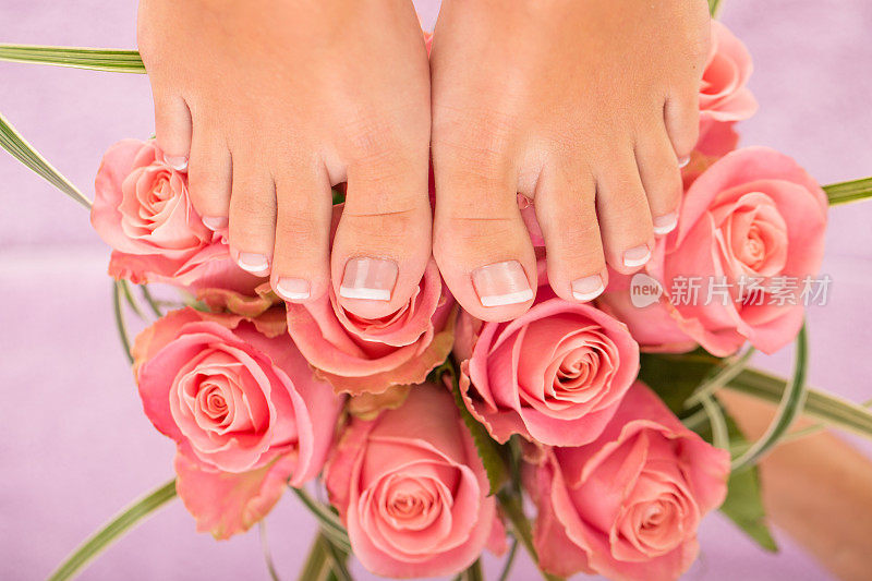 女人在粉红色玫瑰花上修脚后的脚