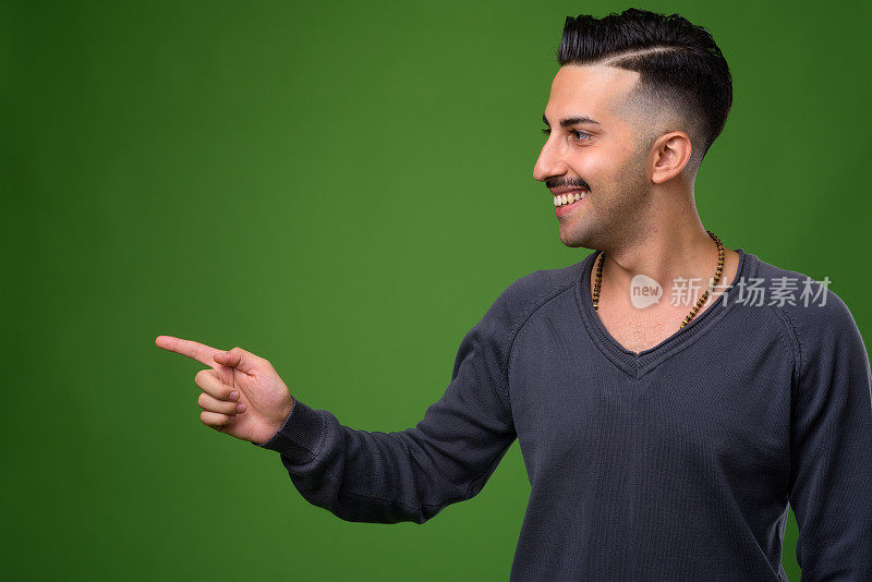 年轻英俊的伊朗男子，在绿色背景下留胡子